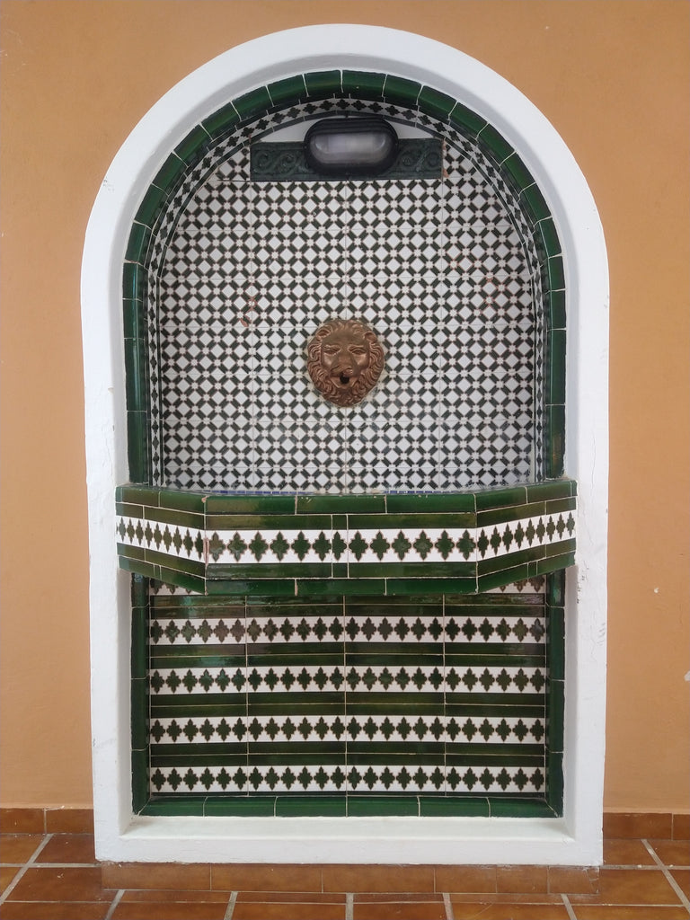 A Spanish fountain with green and white ceramic wall tiles by Alhambra Tiles